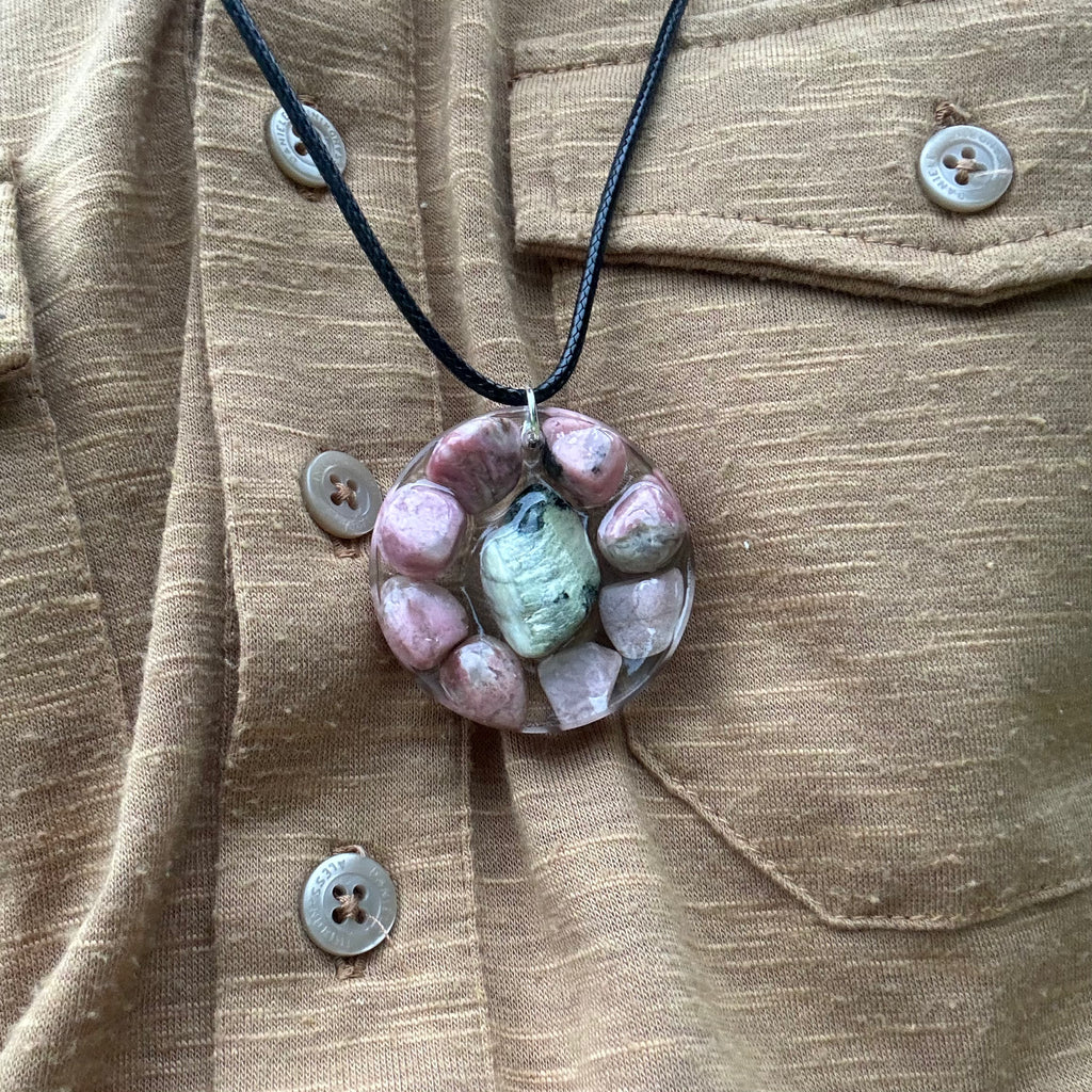 Rodoniet en Serpentijn Edelstenen: Detail van de Rodoniet en Serpentijn stenen in de ketting, symboliseren emotionele genezing en spirituele bescherming.
